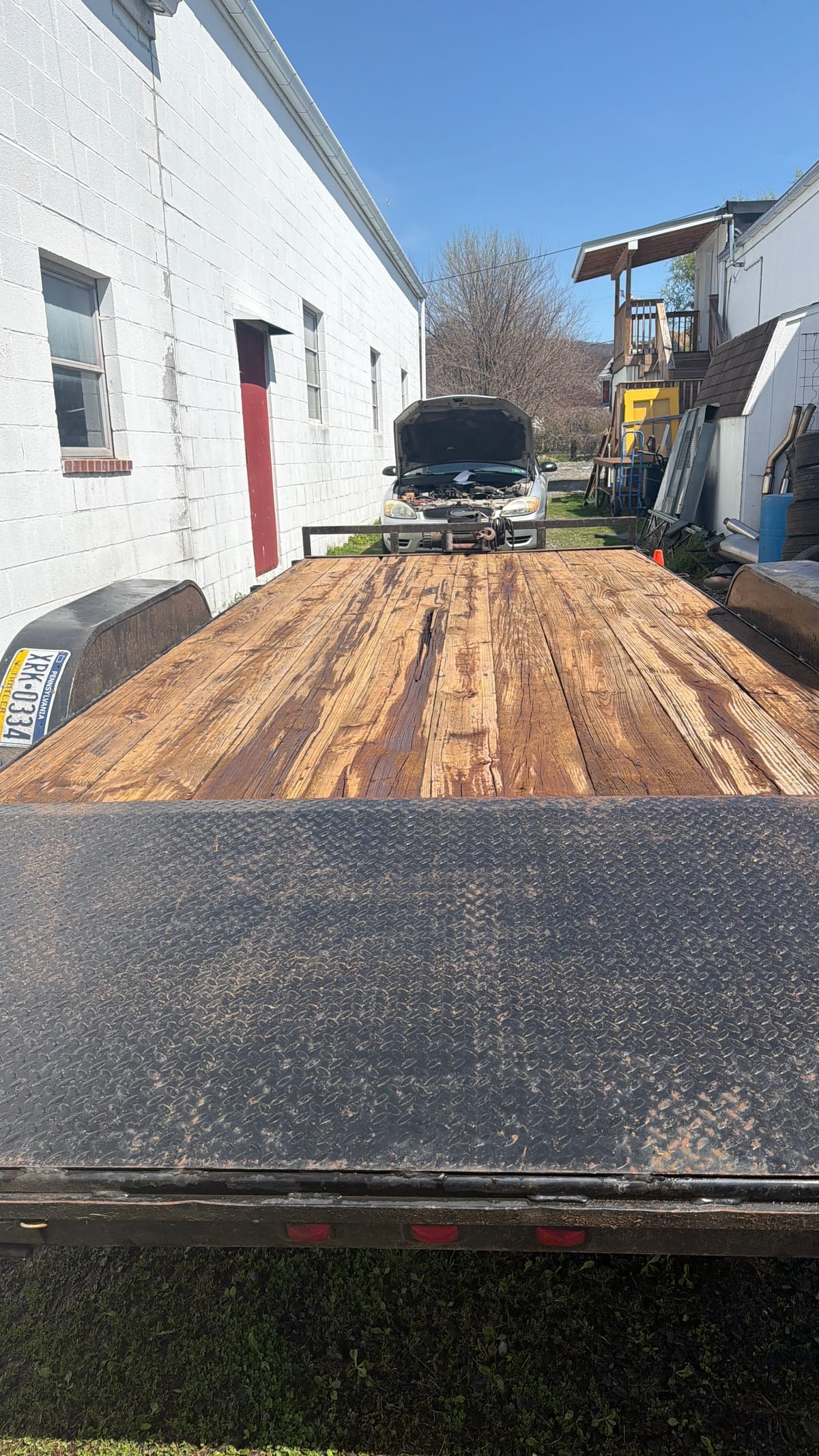 Worn unstained wooden trailer deck before restoration